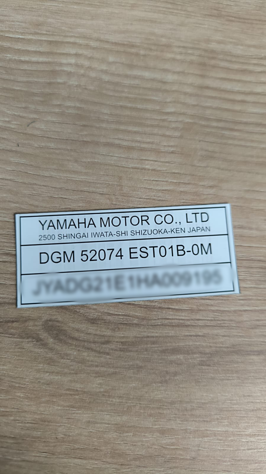 Naklejka znamionowa Yamaha Motor Co. Ltd – folia 0,1 mm, biała, czarne litery, numer VIN JYADG21E1HA009195